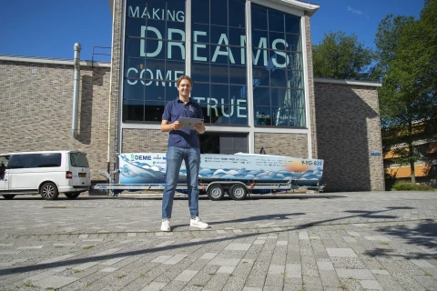 Student Daan in front of the TU Delft dreamhall with the Hydro motion boat